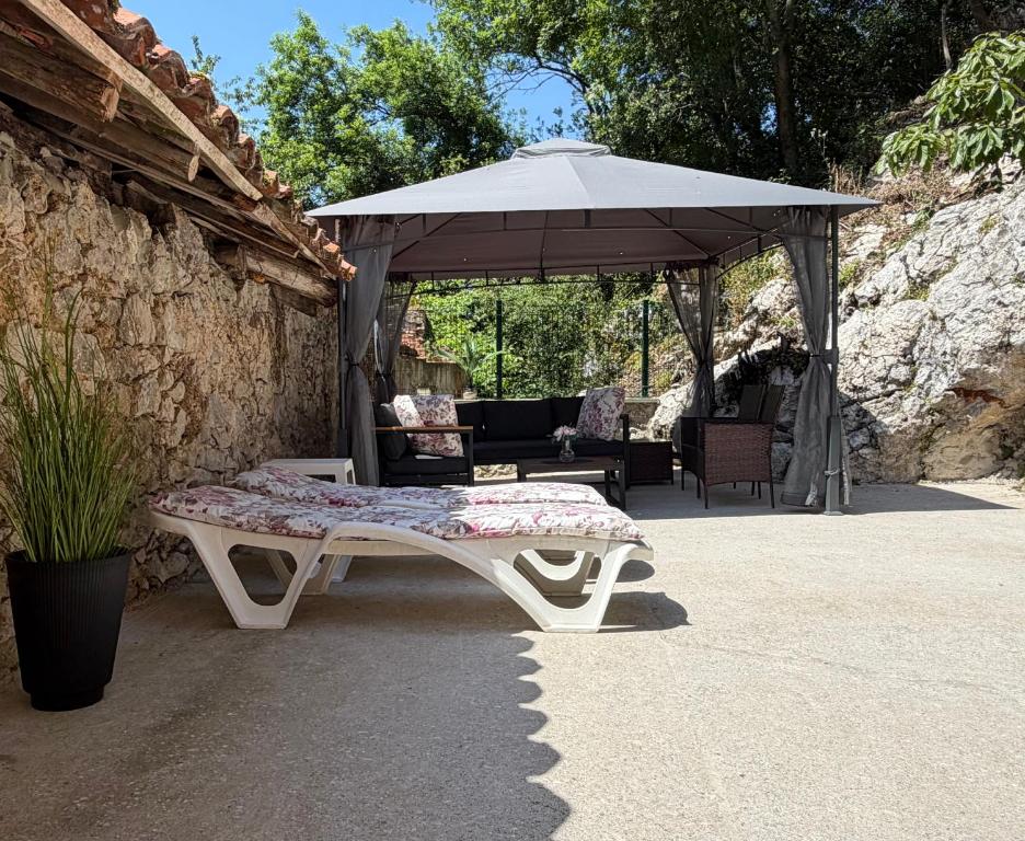 a bench sitting under an umbrella in a patio at Casa Mariyina in Ribadesella