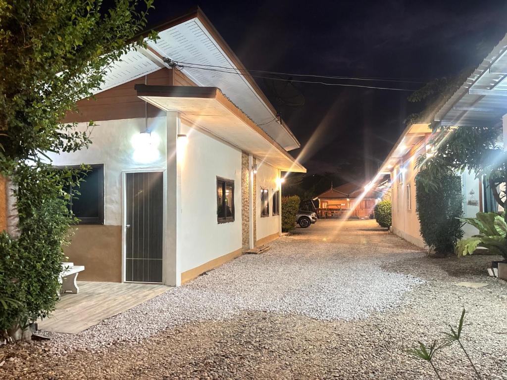 a house with a driveway at night with lights at บ้านหมอบิวรีสอร์ทเชียงคาน BaanmhorbiwResortChiangKhan in Chiang Khan