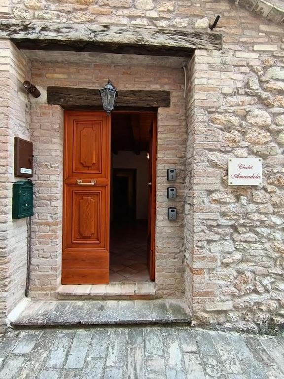 an entrance to a stone building with a wooden door at Chalet Amandola in Moglietta
