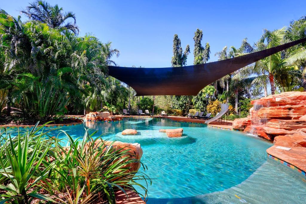 a swimming pool with a hammock in a resort at Habitat Resort in Broome