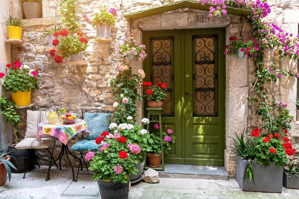 an entrance to a house with a green door and flowers at Casa Nora in centre of Vodnjan - Happy Rentals in Vodnjan