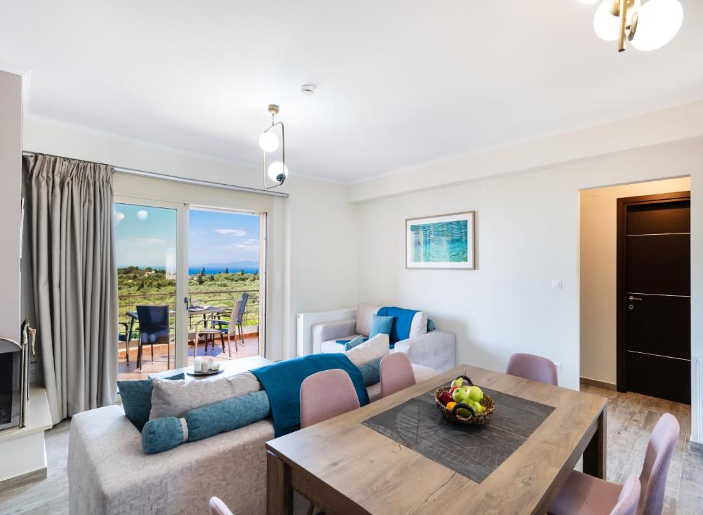 a living room with a couch and a table at Cataleya - Sea & Sunset View Apartment in Tsoukalades