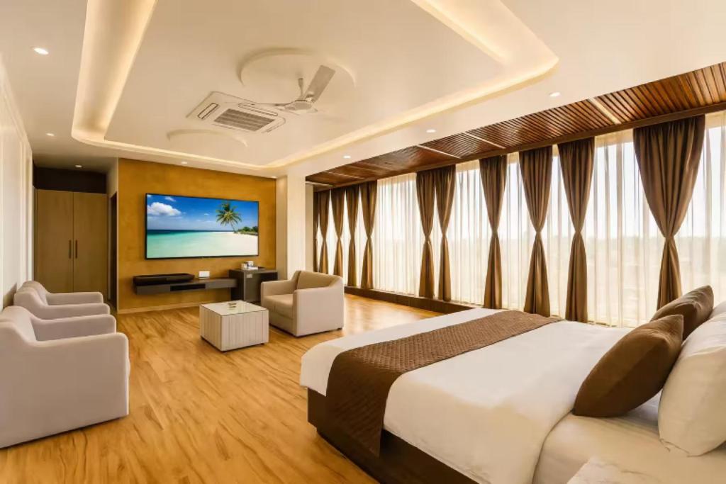 a hotel room with a bed and a flat screen tv at Hotel Manglam Inn Near CCS International Airport in Lucknow