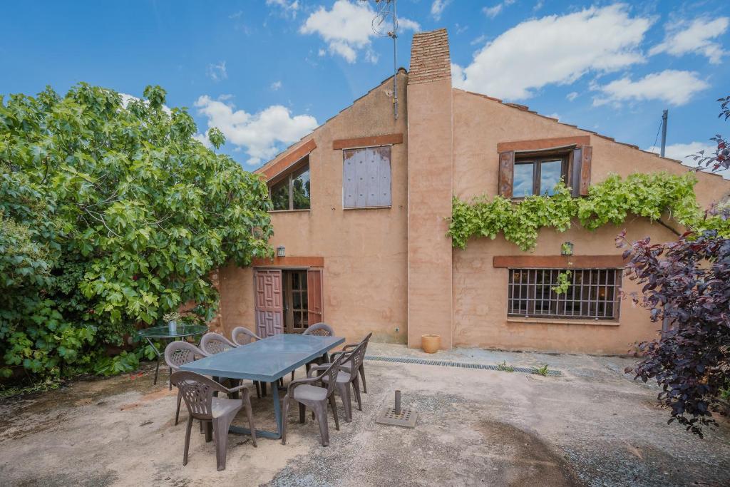 a house with a table and chairs in front of it at Casa La Romana in Ayllón