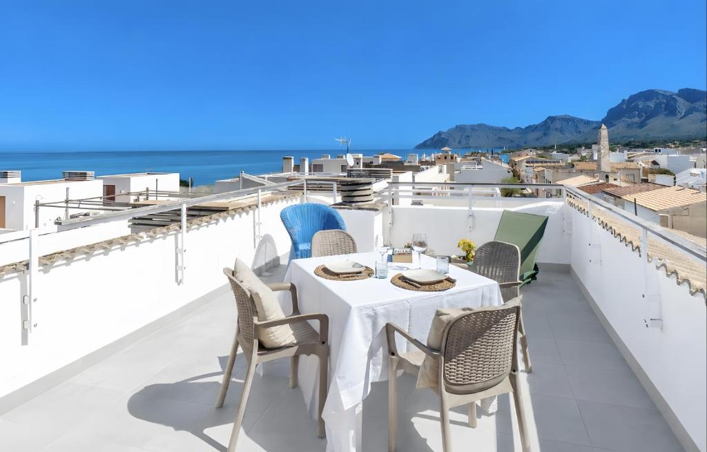 a table and chairs on a balcony with a view of the ocean at Miramar in Artá