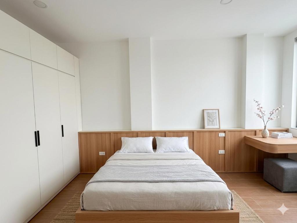 a bedroom with a large bed and a desk at Urban Nest - Cầu Giấy in Hanoi