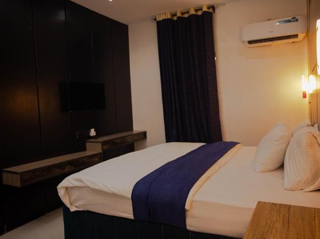 a hotel room with a bed and a television at Maxbliss Optimum Royal Hotel in Benin City