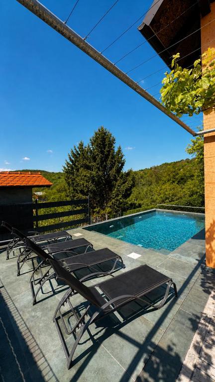 a group of lounge chairs next to a swimming pool at Holiday home Damian - Private pool in Ðurđekovec