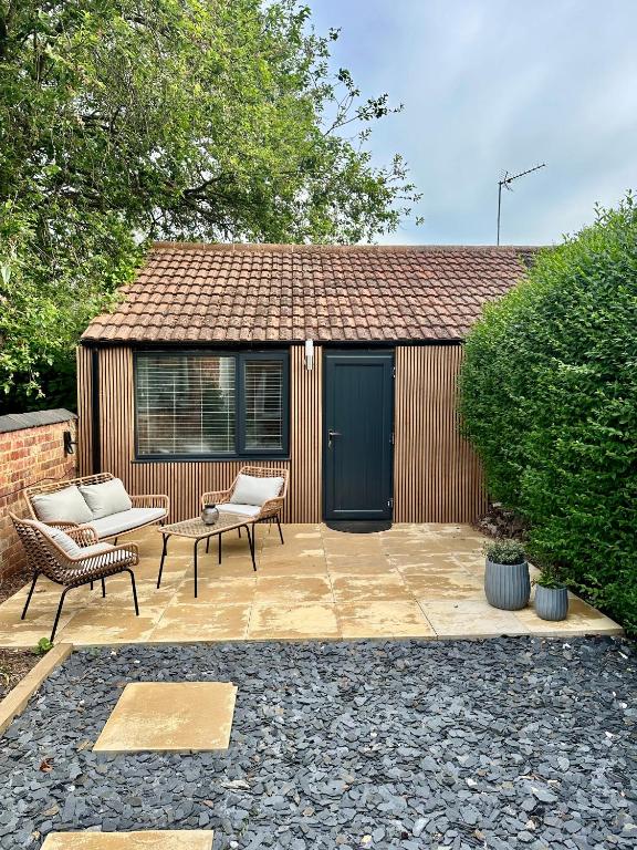 a patio with two chairs and a shed at Kettering Railway Lodge in Kettering