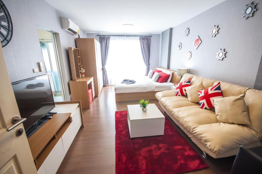 a living room with a couch and a red rug at Baan Imm Aim Condo Hua Hin in Hua Hin