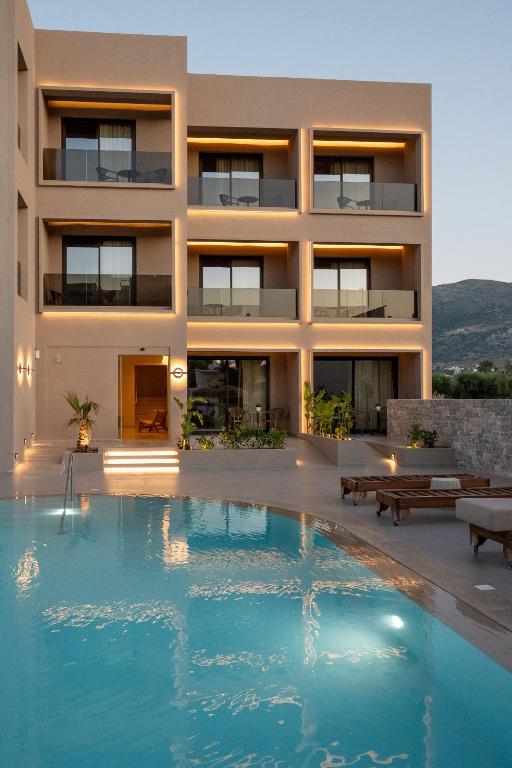 a house with a swimming pool in front of it at Stella Maria Hotel & Suites in Malia