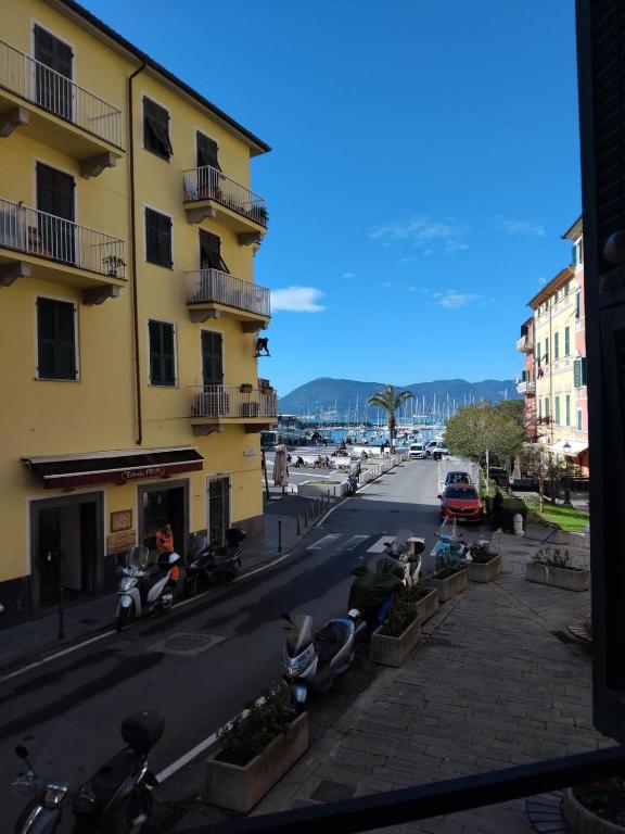 a city street with a yellow building and parked motorcycles at Petriccioli seaview in Lerici