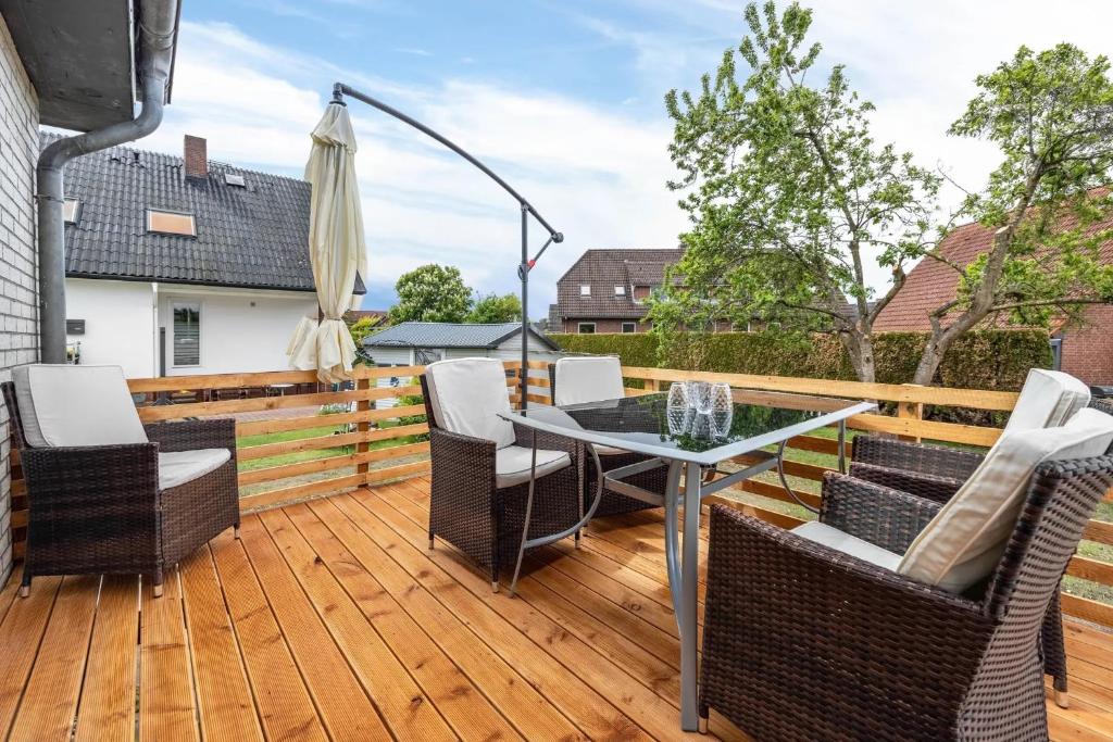a patio with a table and chairs on a wooden deck at Ferienhaus Plüschenworth in Drochtersen