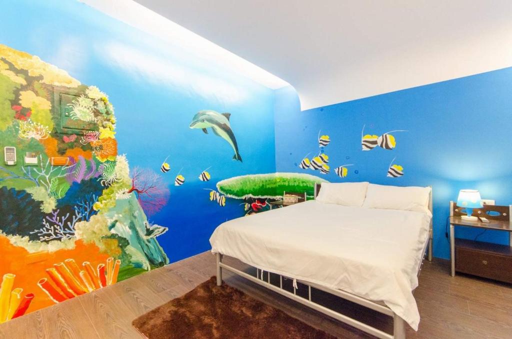 花蓮市にあるApple Houseの青い壁に水中壁画が施されたベッドルーム1室