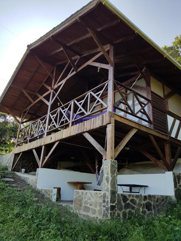 a large wooden building with a dog sitting under it at Duck House Sasaima in Sasaima