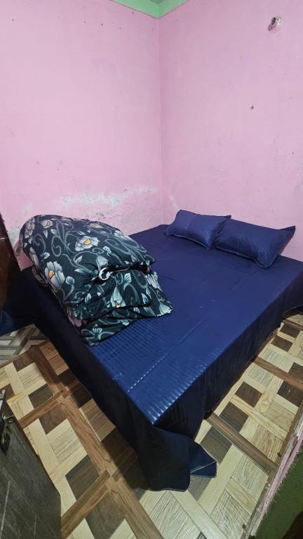 a bed with a blue comforter in a room at Dakshu guest house in Ukhimath
