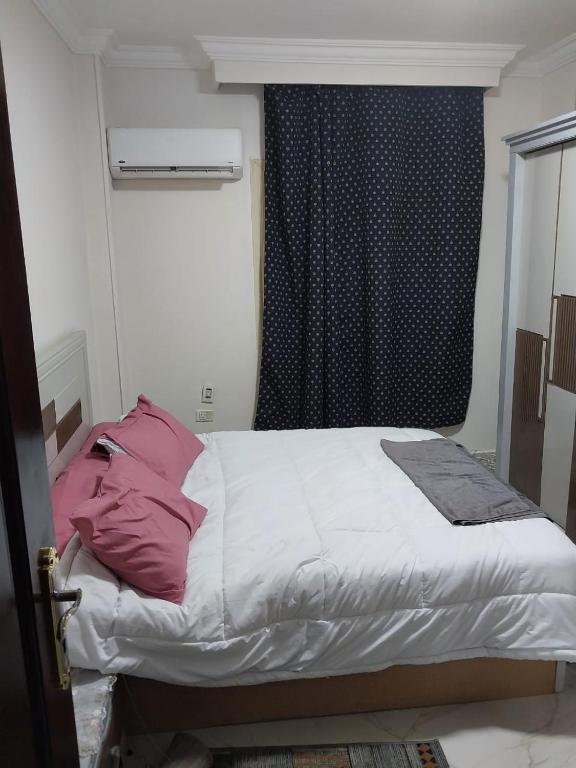 a bed in a room with a window and a bed sidx sidx at شقه ارضي بجردين in ‘Ezbet `Abd el-Ḥamîd