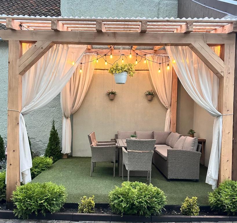 a pergola with a table and chairs on a patio at Eduard Inn in Vulcan