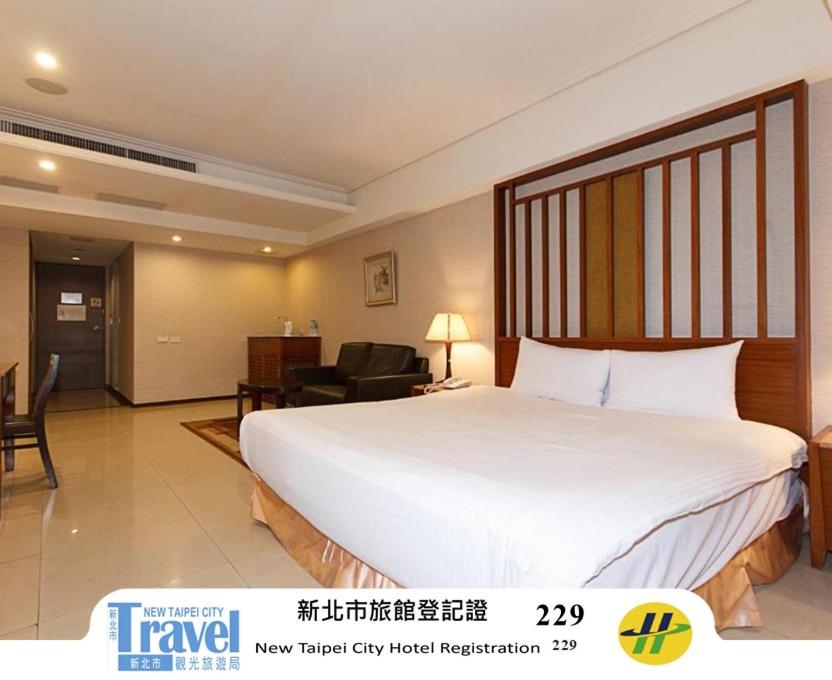 a bedroom with a large white bed in a room at SLV Hotel Group-SLV Business Hotel in Zhonghe