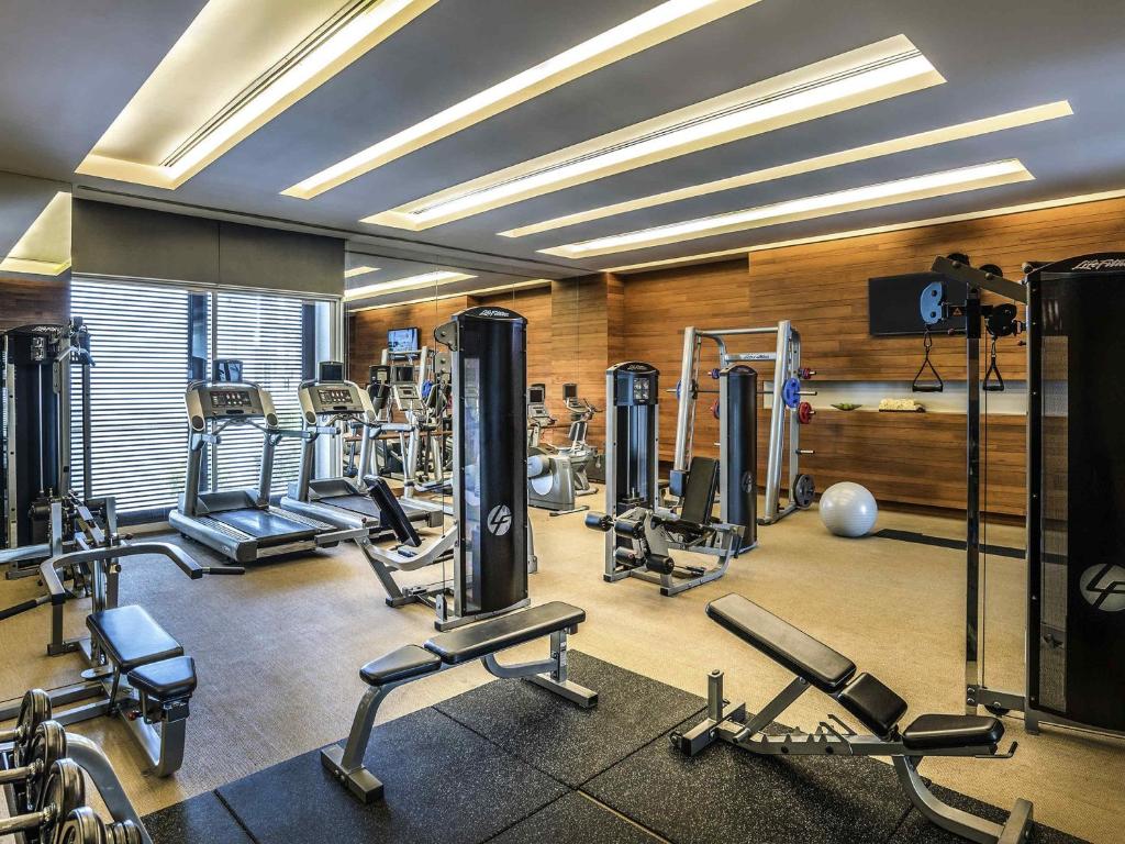 A bright, full-service gym with cardio machines, strength equipment and free weights.