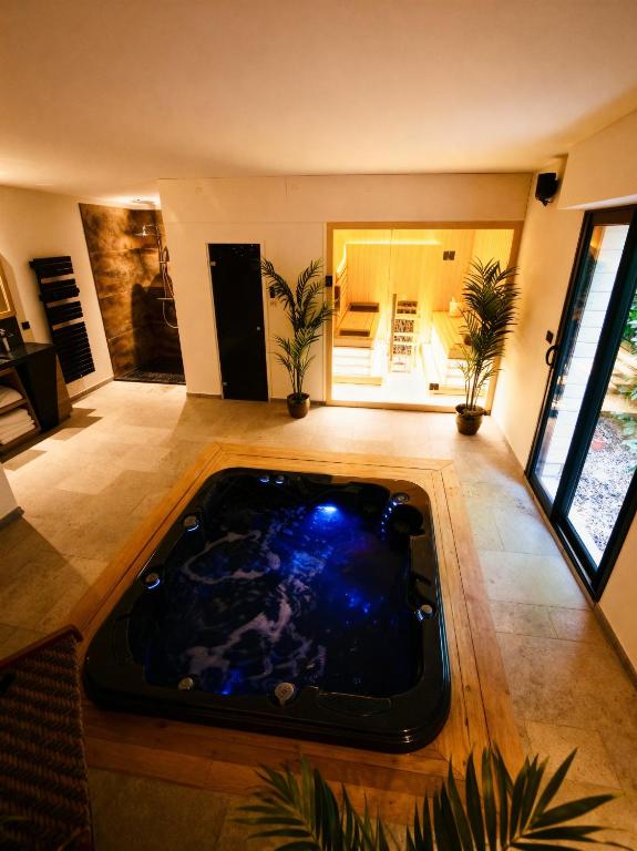 a jacuzzi tub in the middle of a living room at L'ApothéOse, gîte bien-être avec jacuzzi, sauna, hammam in Lieuron