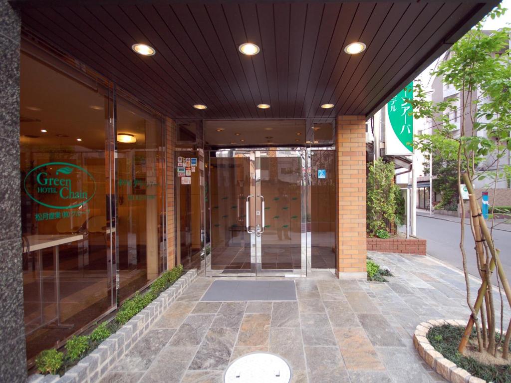 an entrance to a glass building with a revolving door at Hotel Green Arbor in Sendai