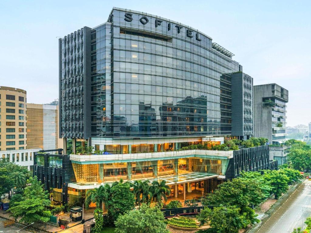 a tall building with a sign on the side of it at Sofitel Mumbai BKC in Mumbai