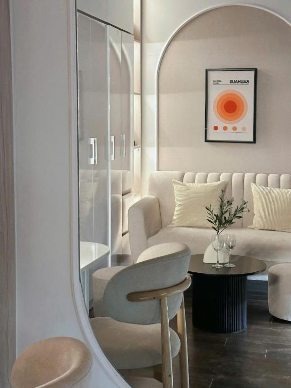 a living room with a couch and a chair and a mirror at Lumi Homestay in Phú Thú