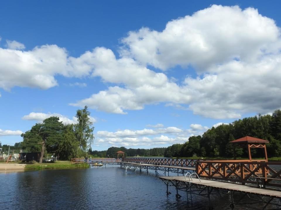 a bridge over a body of water with a gazebo at Apartament nad jeziorem Rosnowo in Rosnowo