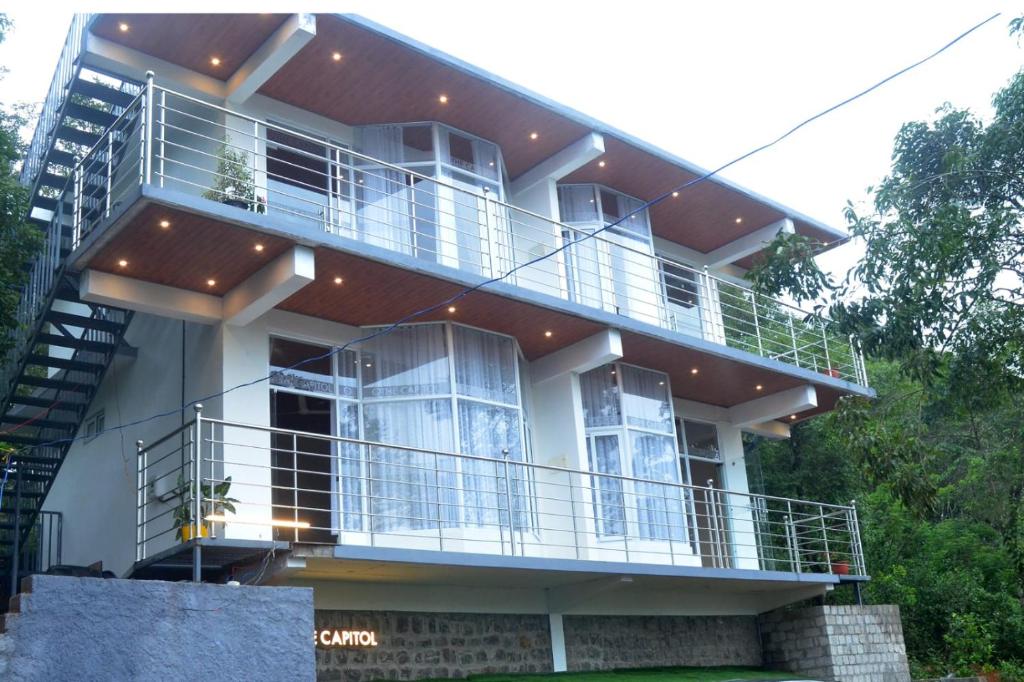 a large white house with a large balcony at The Capitol Homestay in Pīrmed