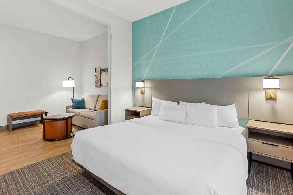 a bedroom with a large white bed and a couch at Comfort Suites Hotel and Conference Center in Berlin