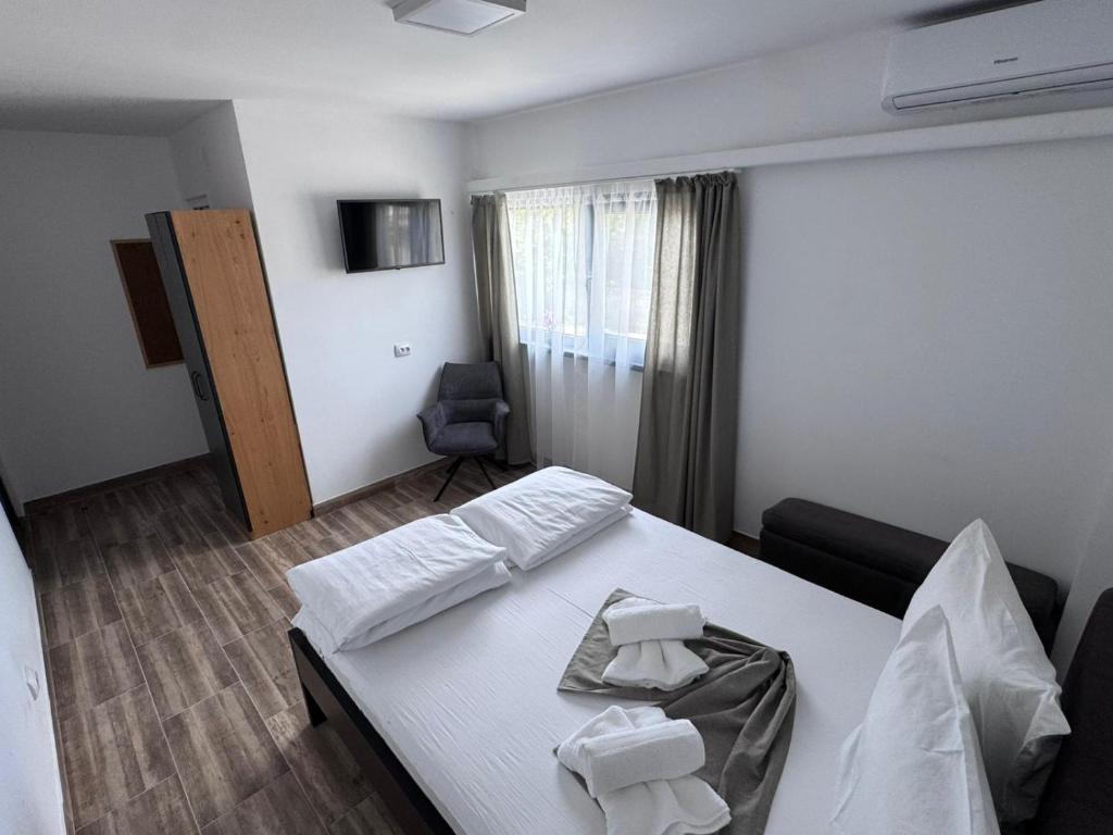 a hotel room with a bed and a chair at Oxygen Rooms in Hunedoara