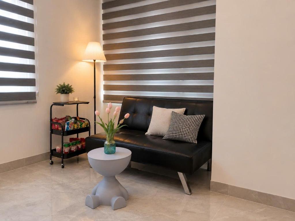 a living room with a black couch and a table at Mun Room in Hai Phong