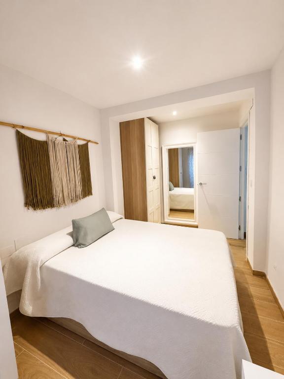 a white bedroom with a large white bed in it at Tranquilo in Elche