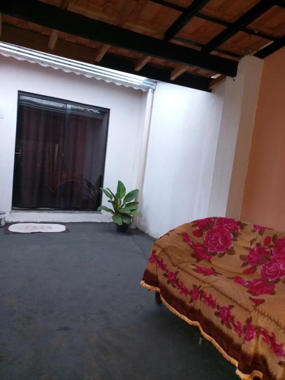 a bedroom with a bed in a room with a window at chalé casa na mata céu Iluminado in Guararema