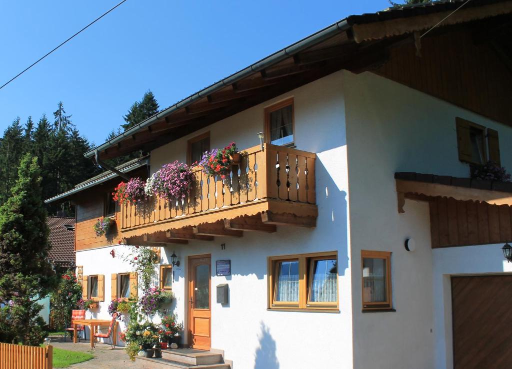 ein weißes Haus mit einem Balkon mit Blumen darauf in der Unterkunft Gästehaus Kurz in Berchtesgaden