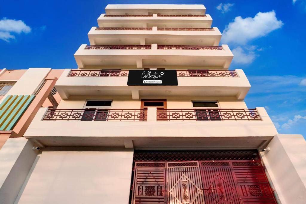 a tall white building with a sign on it at Super Collection O Zero Mile Patna Formerly Chandrashila Residency in Gulzārbāgh