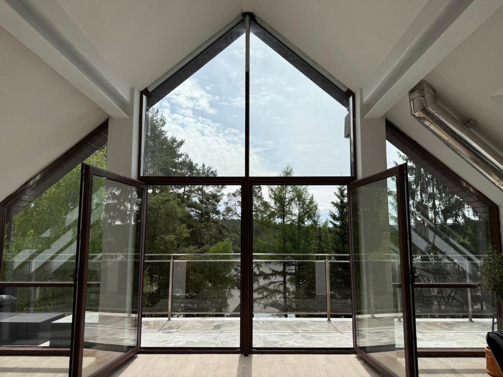 an open glass door in a house with a view at Apartament Art & Lake View in Gryzliny