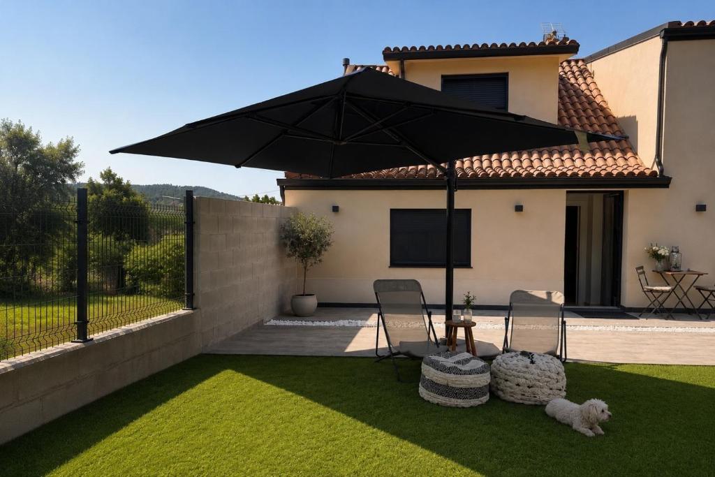 a patio with a table and two chairs and an umbrella at Casa Muxía Mar y montaña in Muxia