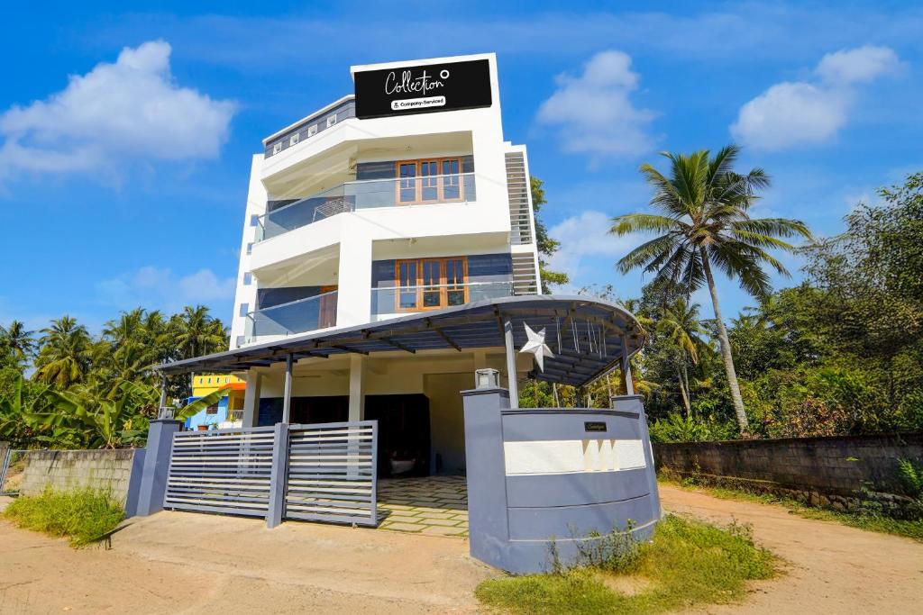 a white building with a sign on top of it at Super Collection O Technopark Phase 1 Formerly Snehalayam in Trivandrum