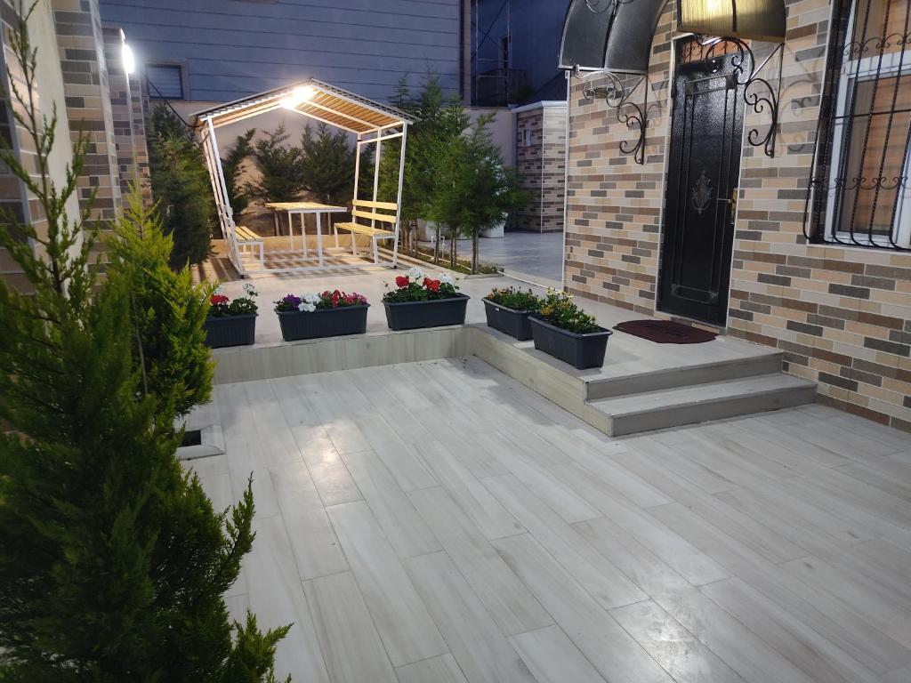 a patio with potted plants and a table on a building at Beach House Buzovna in Baku