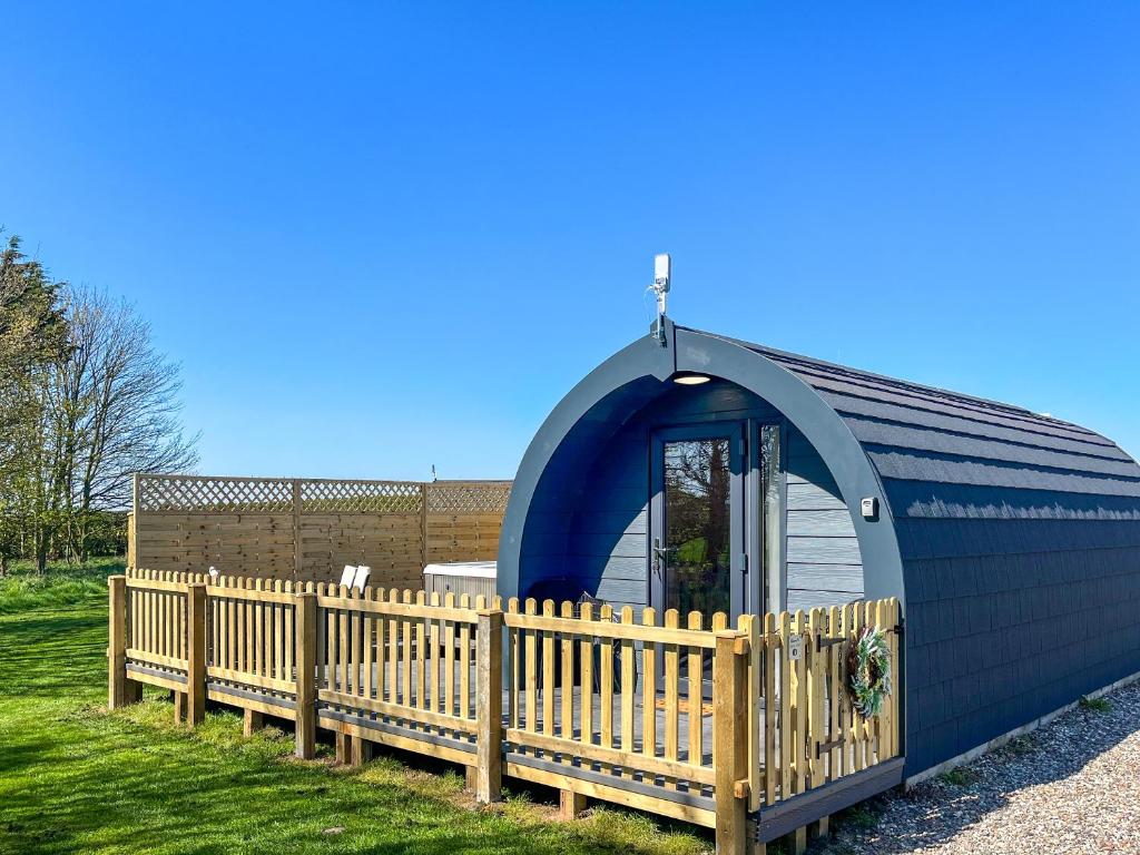 a small blue building with a wooden fence at Birch - Uk51862 in Reighton