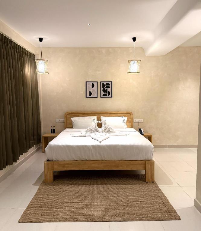 a bedroom with a bed and two pendant lights at NestSort Hotel in Mysore