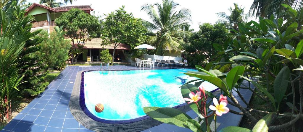 una piscina frente a una casa en Damith Guest House, en Unawatuna