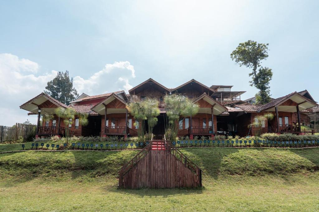 a house with a tree in front of it at RB Cottage Resort By ARBA in Palayangan