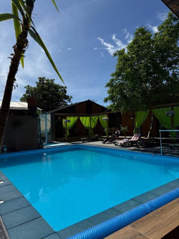 a large blue swimming pool next to a house at Villa Magnat in Berehove