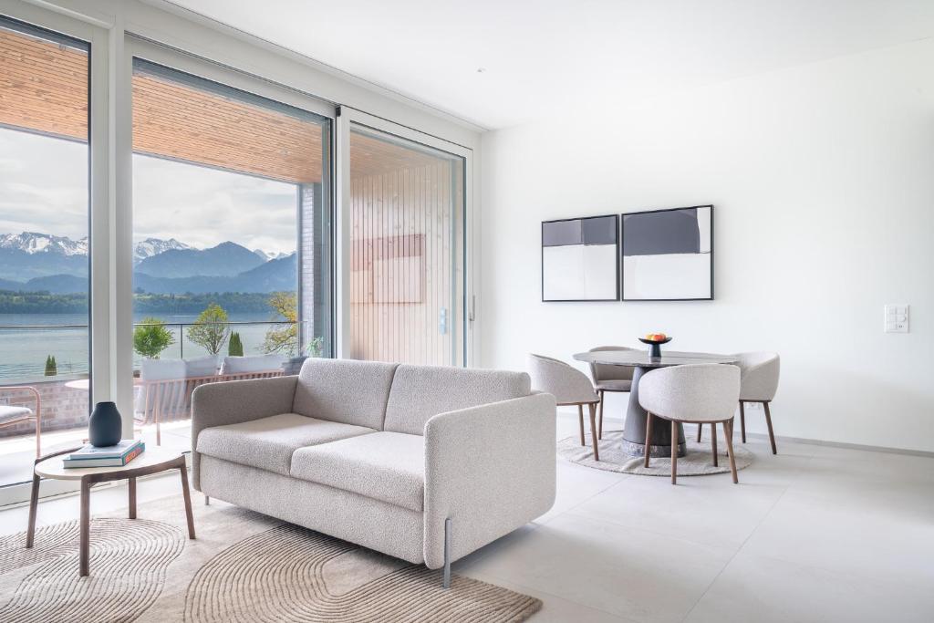 a living room with a couch and a table at Rigi Lakeside Apartments in Merlischachen
