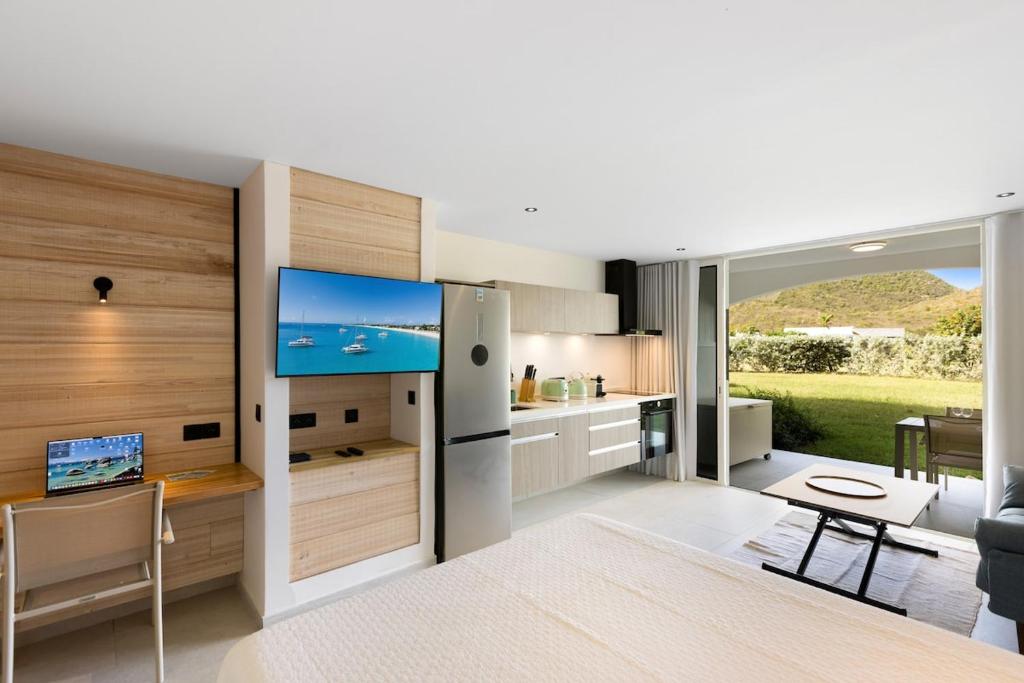 a kitchen with a living room with a tv in it at Sun et Sea Dreams in Anse Marcel 