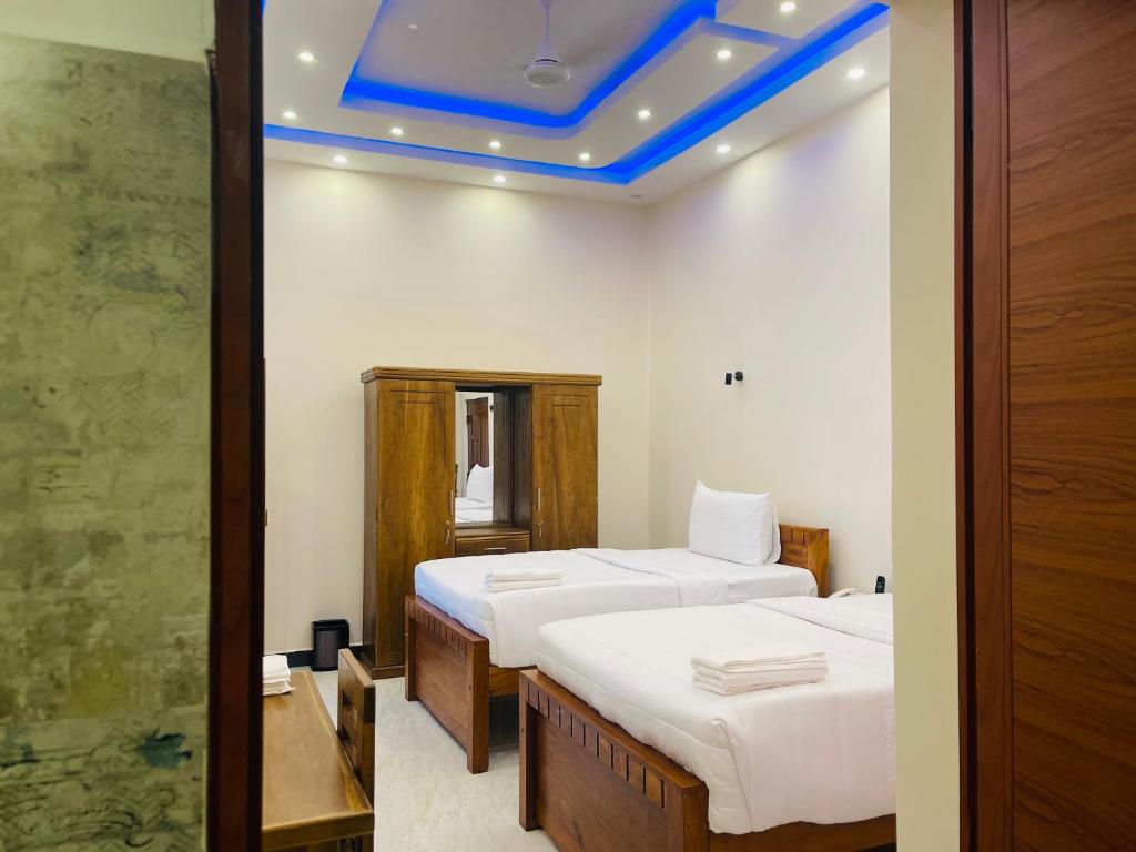 a room with two beds and a blue ceiling at Infenta's Villa Hotel & restaurant in Pandattarippu