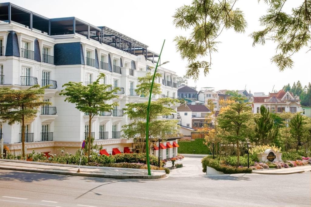 a large white building with trees in front of it at Golden Sun Hotel - Dalat in Da Lat
